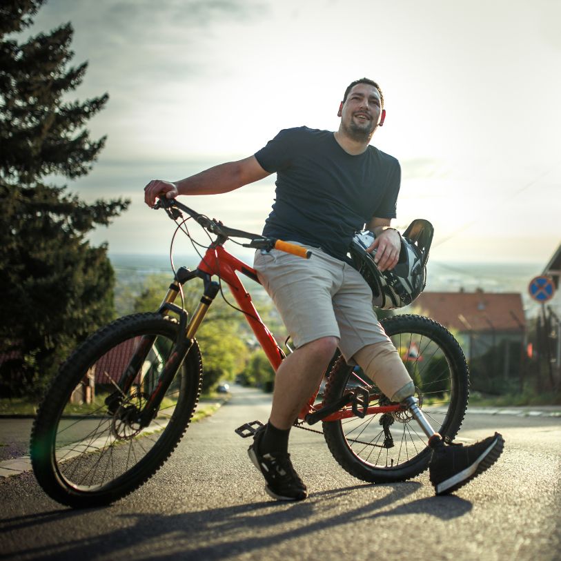 Person with prosthetic leg enjoying outdoor activities on a bicycle